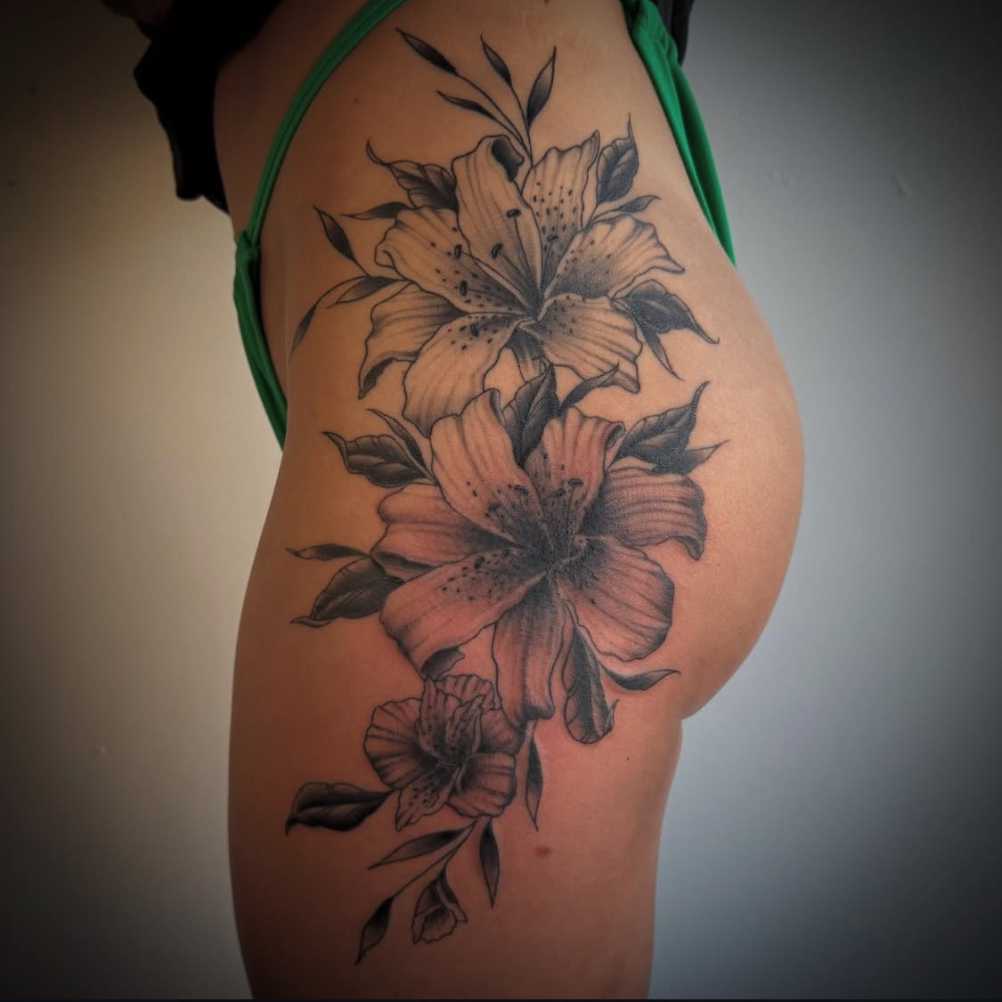 Black and grey lily flowers hip tattoo by Byron Rojas
