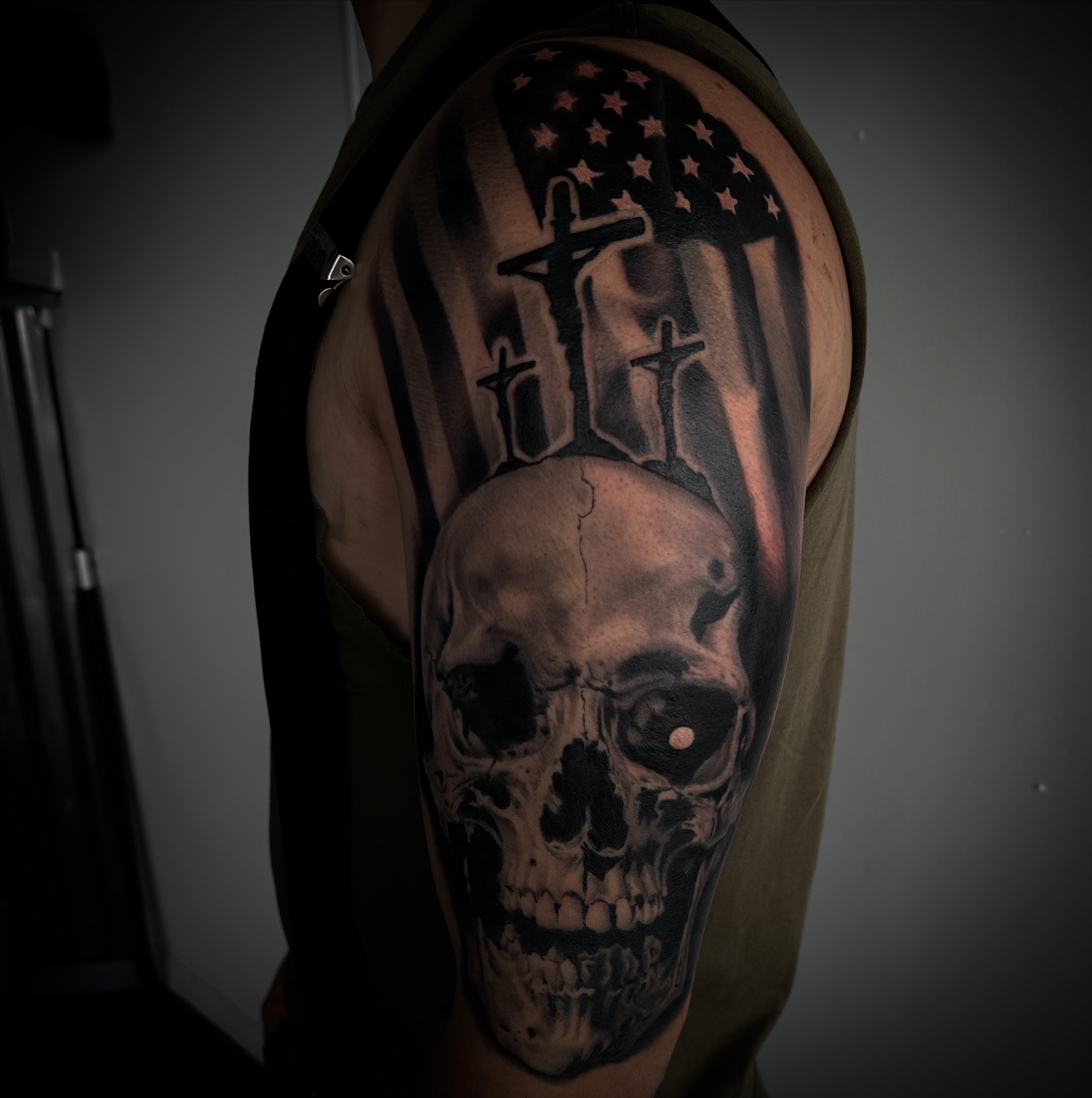Black and grey skull with American flag tattoo by Byron Rojas