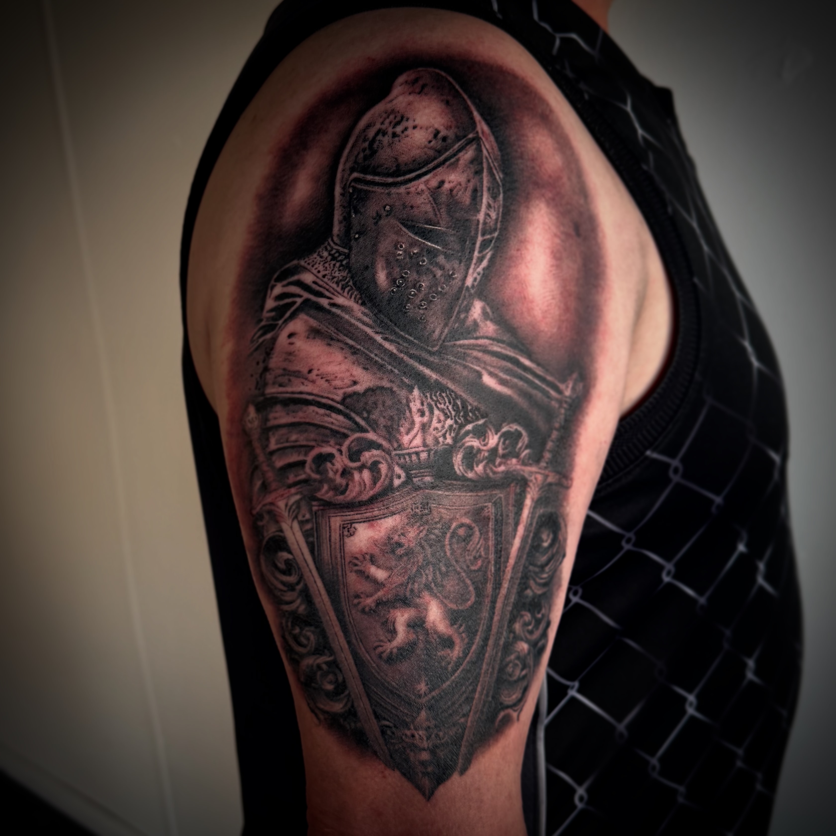 Black and grey armored knight with crest tattoo by Byron Rojas